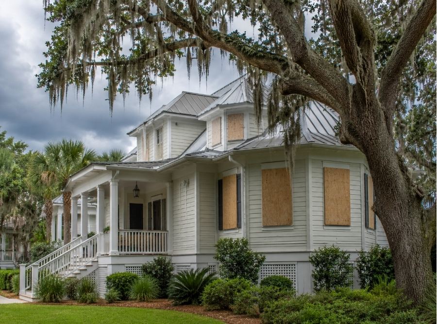 Beaufort, South Carolina coastal home prepared for hurricane season with storm-ready exterior, live oak trees, and cloudy Lowcountry skies.